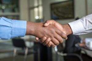 Handshake zwischen Geschäftspartnern als Symbol für Zusammenarbeit und Vertrauen